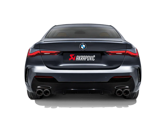 Rear view of a grey BMW with an Akrapovic exhaust, with twin pipes each side, fitted