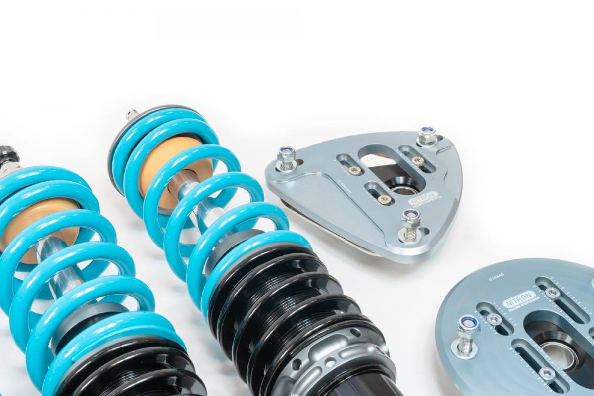 Close up view of 2 partial shock absorbers with coils springs fitted & 2 top mounts