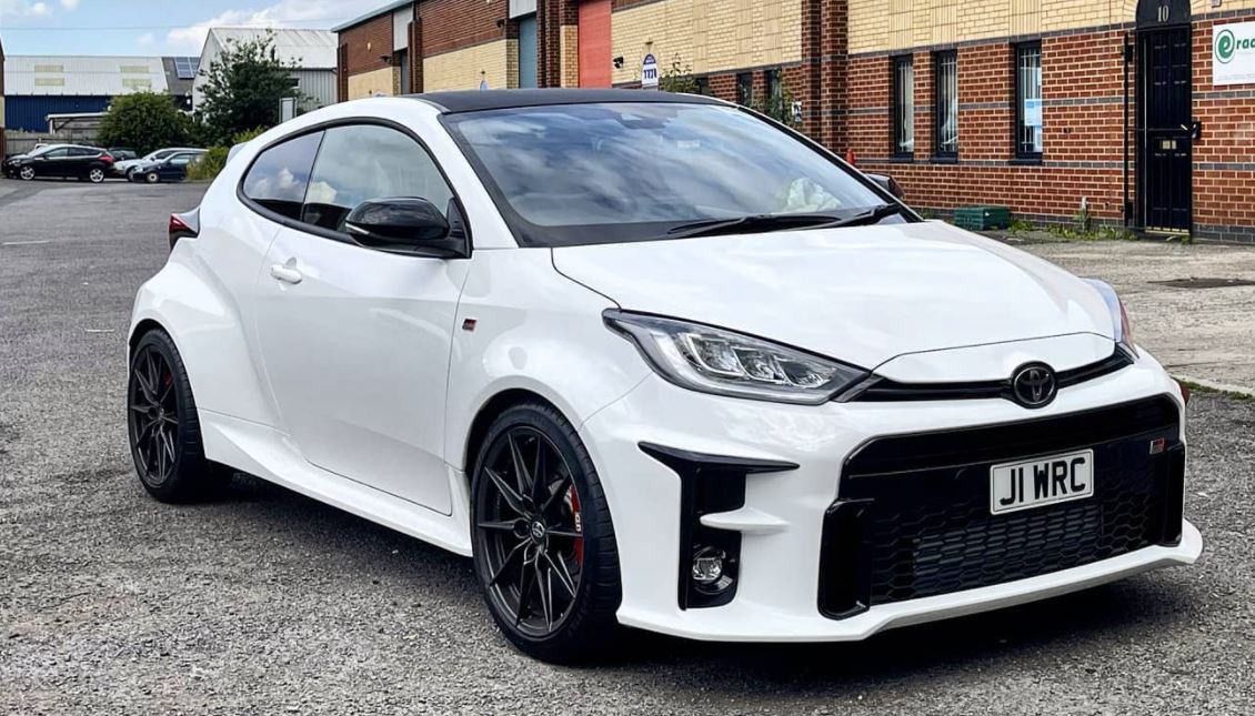 A white Toyota GR Yaris with black trim with the spacer kit fitted, showing the wheels filling the arches more