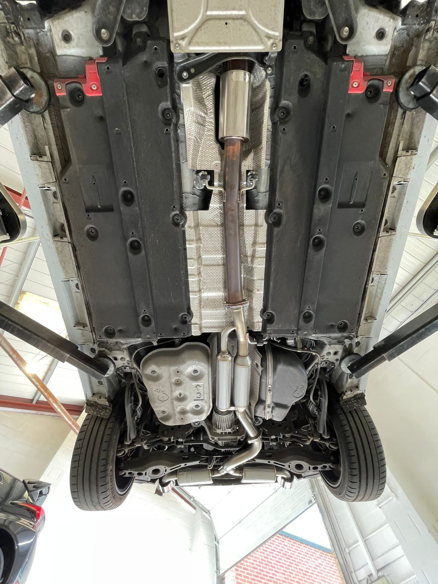 View of the bottom of a vehicle on a ramp with a full exhaust system fitted