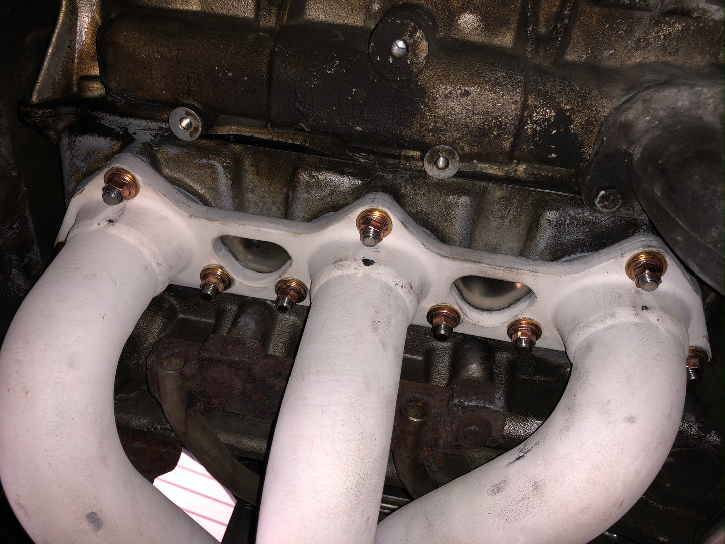 A view of the STG Titanium exhaust manifold stud kit fitted to the vehicle manifold, which i turn is fitted to the engine