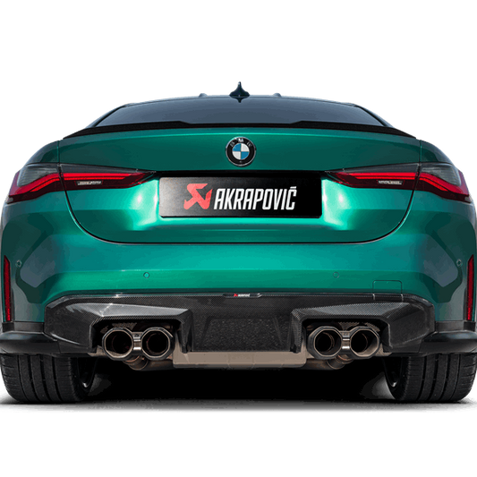 Rear floor level view of a green BMW M4 with an Akrapovic exhaust, with twin pipes each side, and a rear carbon fibre diffuser fitted