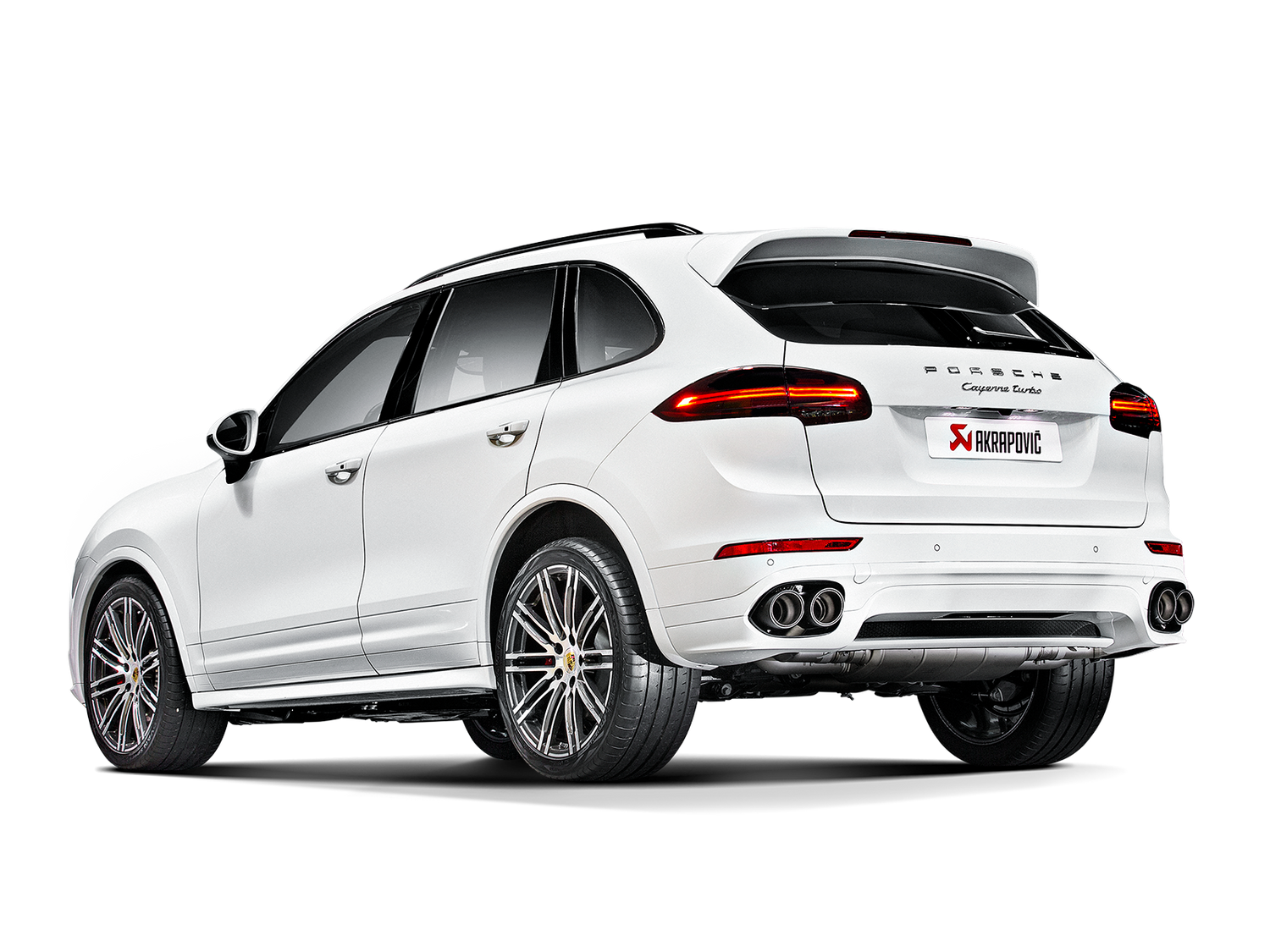 Nearside rear view of a white Porsche Cayenne 958 with silver alloy wheels & an Akrapovič twin, double round exhaust fitted
