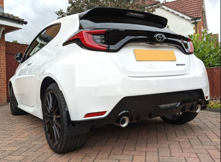 Nearside rear view of a white Toyota GR Yaris with black alloy wheels, black trim & rear mudflaps fitted