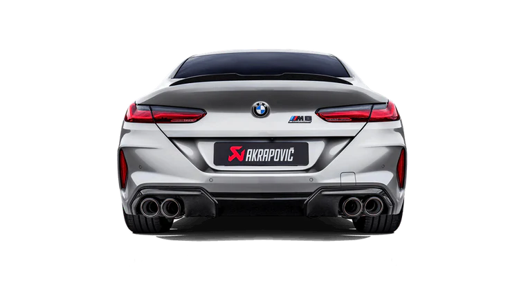 Rear view of a silver BMW M8 with an Akrapovič exhaust with twin pipes on each side fitted