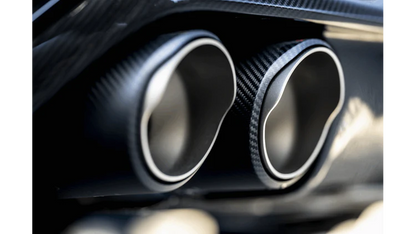 Close up view of a pair of Akrapovič carbon fibre tail pipe tips fitted to a vehicle
