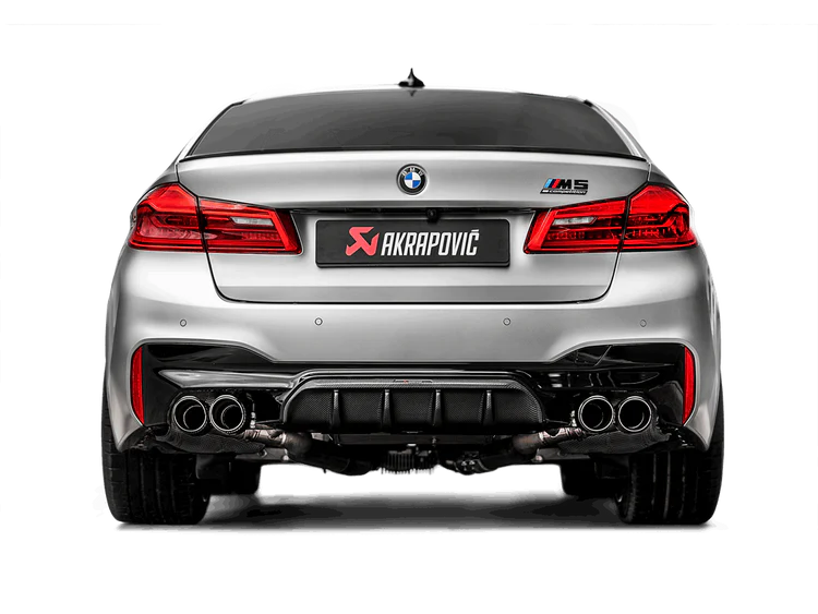Rear view of a silver BMW M5 F90 with an Akrapovic Titanium exhaust with twin pipes each side, a carbon fibre tail pipe set & carbon fibre rear diffuser
