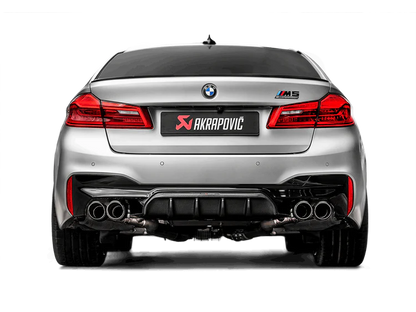Rear view of a silver BMW M5 F90 with an Akrapovic exhaust with twin pipes each side & rear carbon fibre diffuser fitted