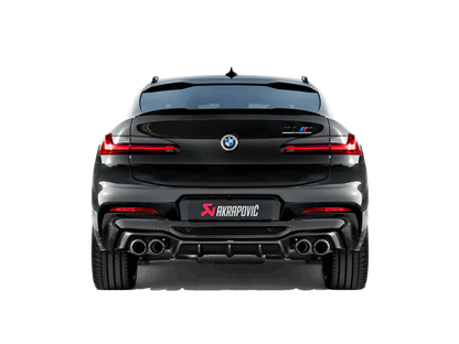 Rear view of a black BMW X4M with an Akrapovič exhaust with twin pipes each side & a carbon fibre rear diffuser fitted