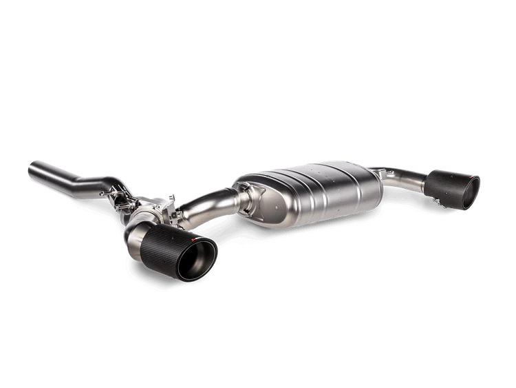An aerial side view of an Akrapovič titanium exhaust system featuring a central muffler and carbon fibre tips either side
