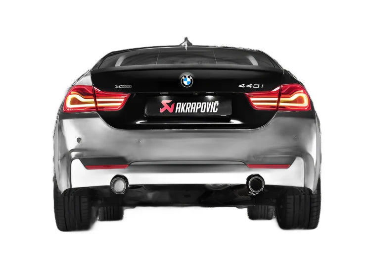 Rear view of a BMW 440i with Akrapovič exhaust, on white background.