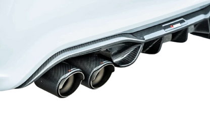 Close-up of a white car's rear with Akrapovic carbon fibre exhaust tips and diffuser