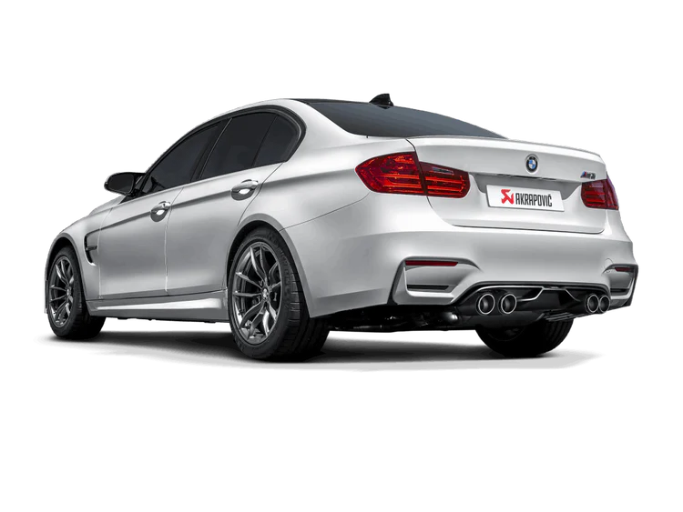Near side rear view of a silver BMW M4 with an Akrapovic exhaust, with twin pipes each side, & a carbon fibre rear diffuser fitted