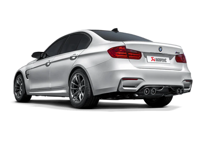 Near side rear view of a silver BMW with an Akrapovic exhaust, with twin pipes each side, & rear carbon fibre diffuser fitted