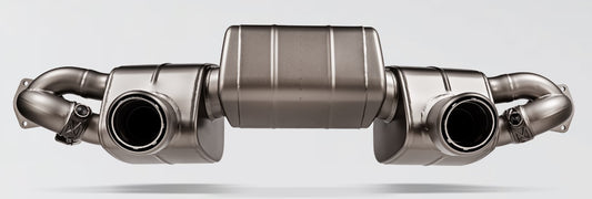 Frontal view of an Akrapovič rear section exhaust with 3 mufflers and a pipe each side with carbon fibre tips