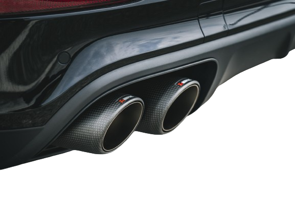 View of a pair of Akrapovič twin double round tail pipes with a carbon fibre finish fitted to a vehicle with a rear diffuser