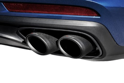 View of a pair of Akrapovič twin double round tail pipes with a carbon fibre finish fitted to a vehicle with a rear diffuser