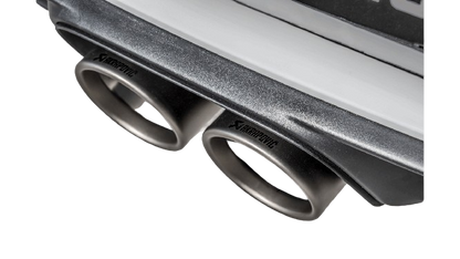Close up view of an Akrapovič double round Titanium tail pipe set fitted to a Porsche with an Akrapovič carbon fibre rear diffuser