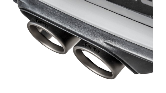 Close up view of an Akrapovič double round Titanium tail pipe set fitted to a Porsche with an Akrapovič carbon fibre rear diffuser