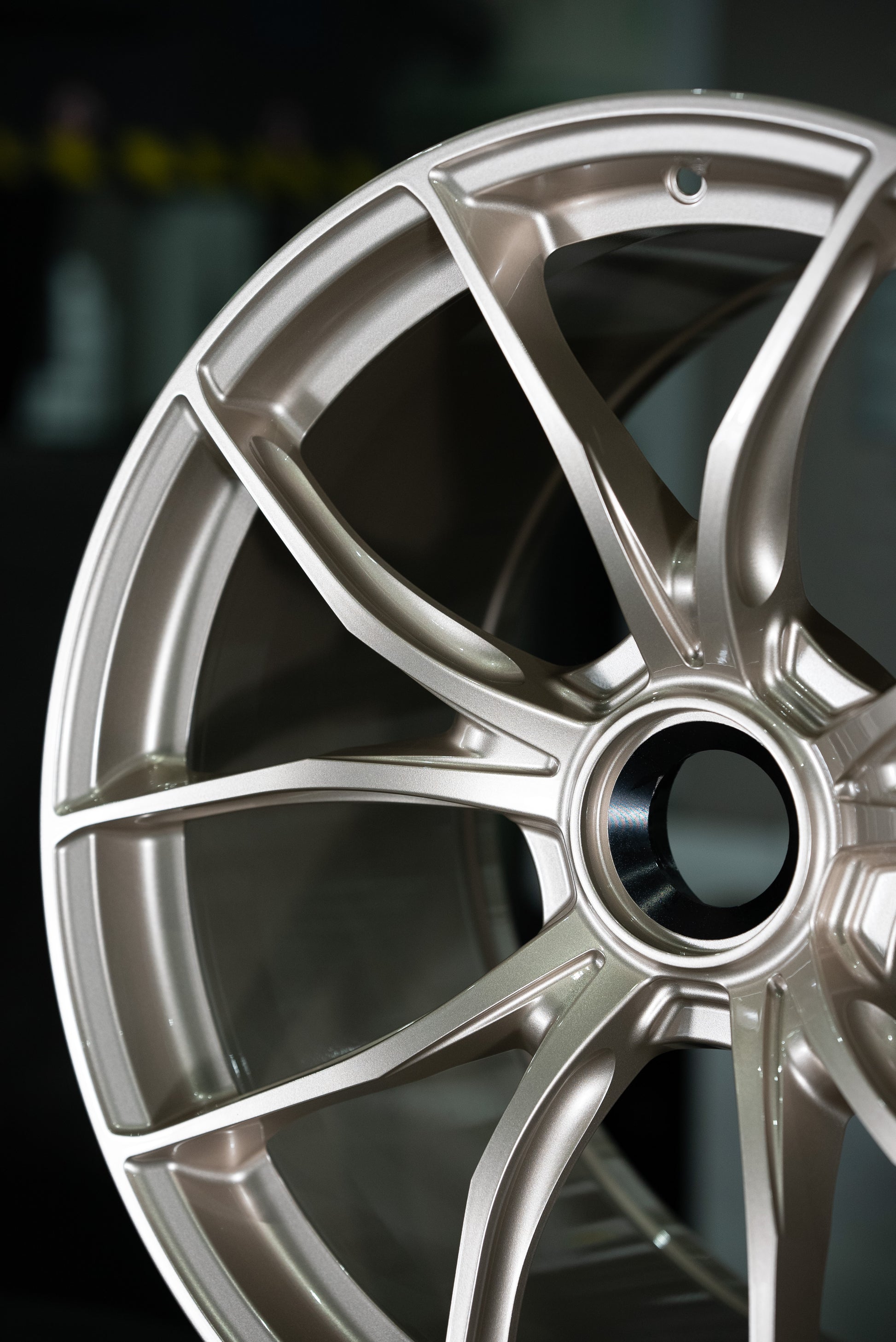Close up view of a two thirds of an IPE MFR-01 Magnesium wheel in silver with a multi-spoke design against a white background