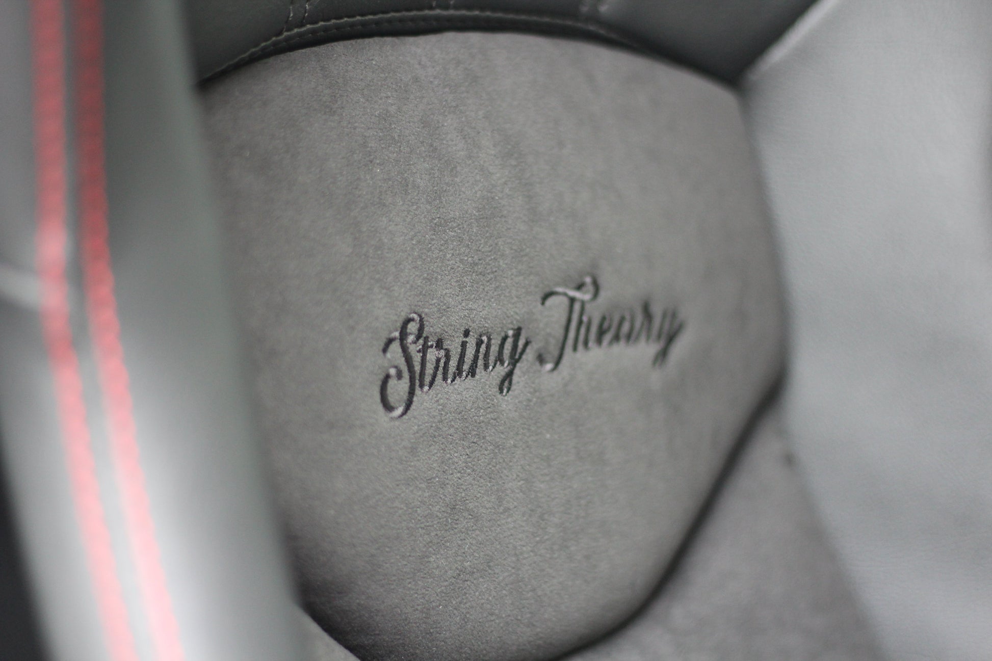 Close up view of the String Theory name sewn into the back rest of the seat
