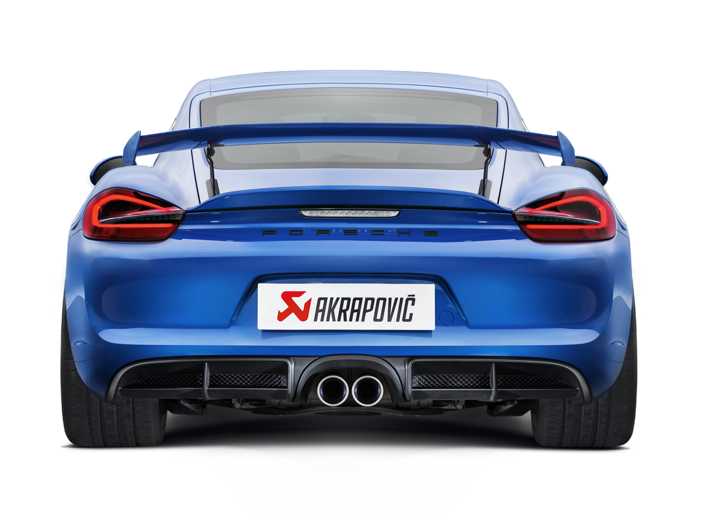 Rear view of a Blue Porsche Cayman 981 GT4 with rear spoiler & an Akrapovič rear exhaust with twin round pipes fitted