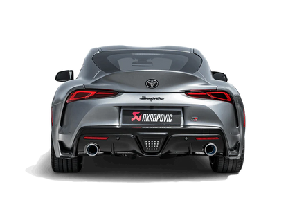 Rear view of a grey Toyota Supra A90 with an Akrapovič titanium exhaust, with twin pipes, fitted