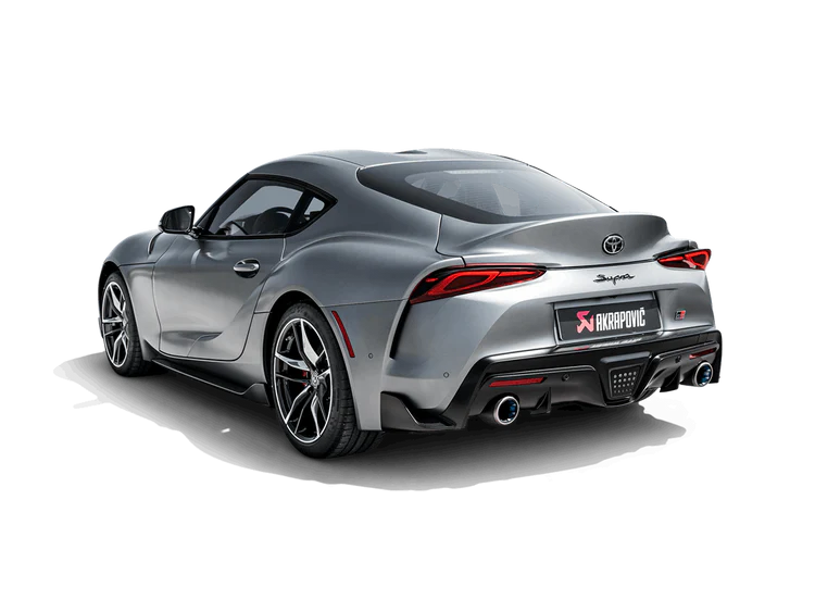 Nearside rear view of a grey Toyota Supra A90 with an Akrapovič titanium exhaust, with twin pipes, fitted