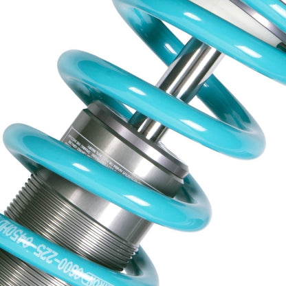 Close up of part of a shock absorber & light blue coil spring