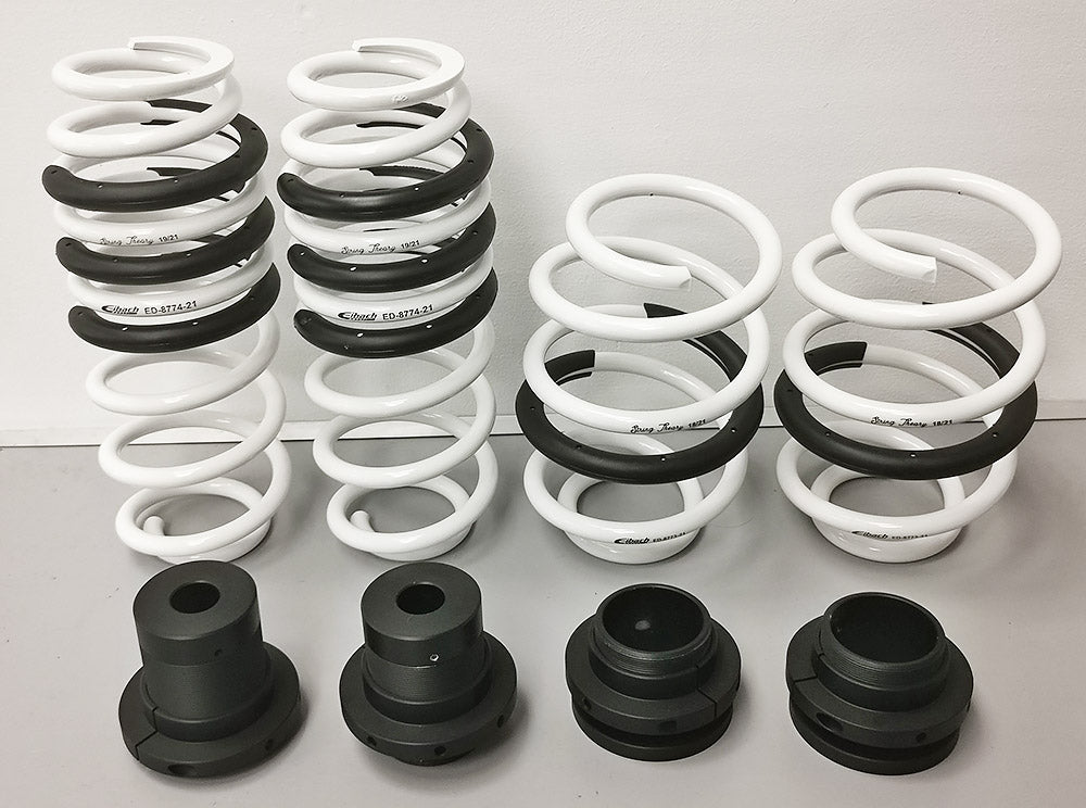 Front aerial view of a set of 4 white coil springs with with black trimming & black top mounts