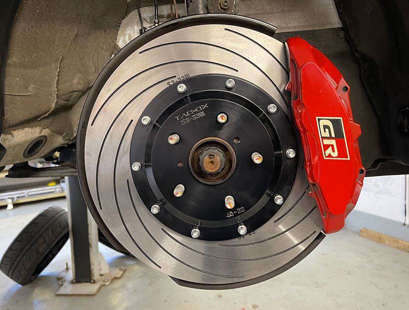 Front view of a Tarox grooved brake disc fitted to a vehicle with a red GR brake caliper